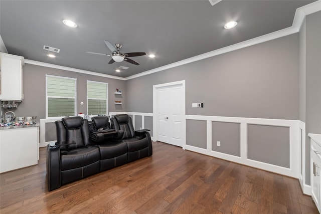 cinema featuring dark hardwood / wood-style floors, ceiling fan, and crown molding