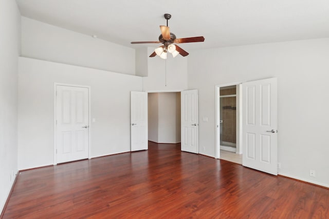 unfurnished bedroom featuring ceiling fan, high vaulted ceiling, and dark wood finished floors