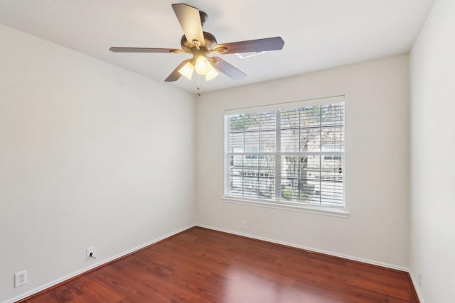 unfurnished room featuring dark wood-style floors, ceiling fan, and baseboards