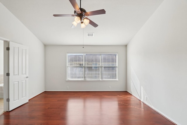 empty room featuring ceiling fan, dark wood-style flooring, visible vents, and baseboards