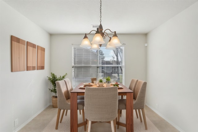 tiled dining space featuring an inviting chandelier