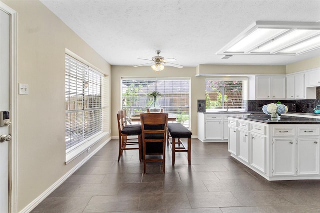 kitchen featuring ceiling fan, sink, tasteful backsplash, a textured ceiling, and white cabinets