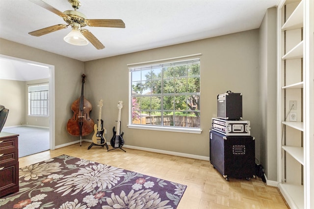 interior space with a wealth of natural light, ceiling fan, and parquet flooring