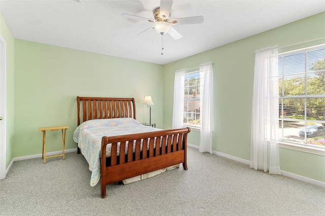 carpeted bedroom with multiple windows and ceiling fan