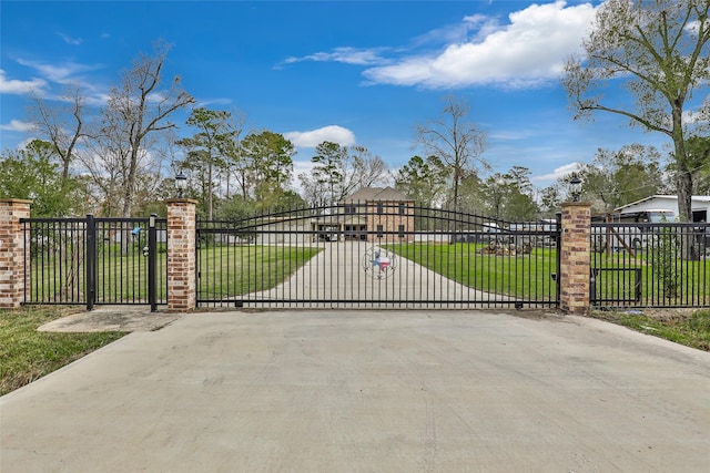 view of gate with a lawn