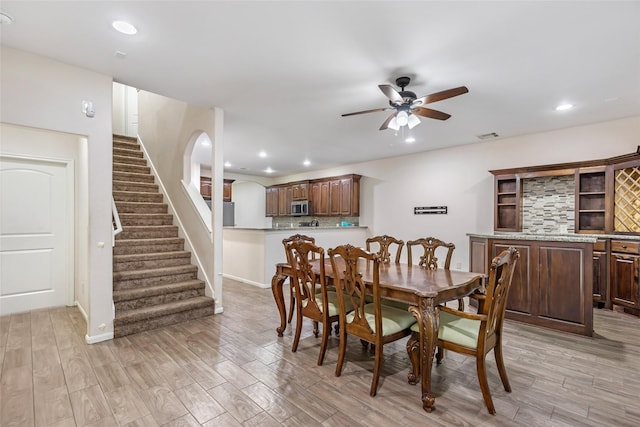 dining area with ceiling fan and light wood-type flooring