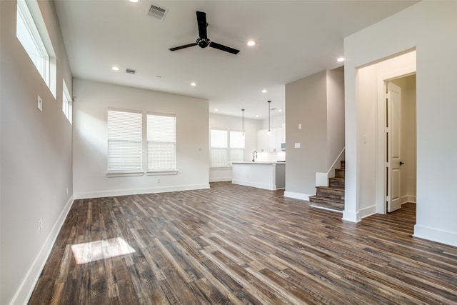 unfurnished living room with dark hardwood / wood-style floors, ceiling fan, and sink