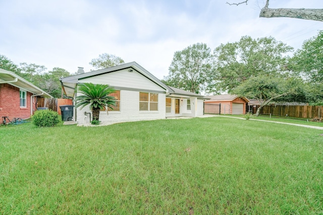 rear view of house with a garage and a yard