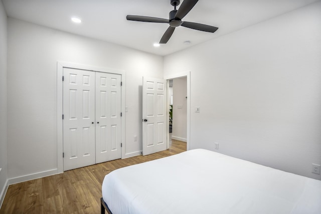 bedroom featuring ceiling fan, wood-type flooring, and a closet