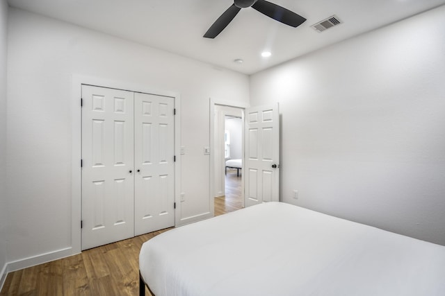 bedroom with ceiling fan, a closet, and hardwood / wood-style flooring