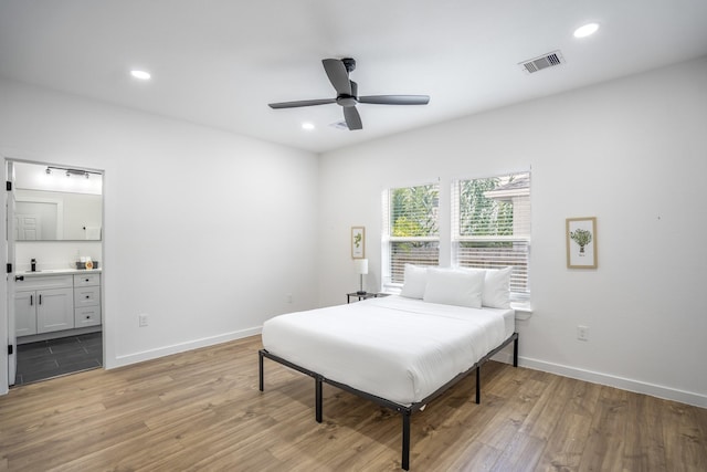 bedroom featuring ceiling fan, ensuite bathroom, and light hardwood / wood-style floors