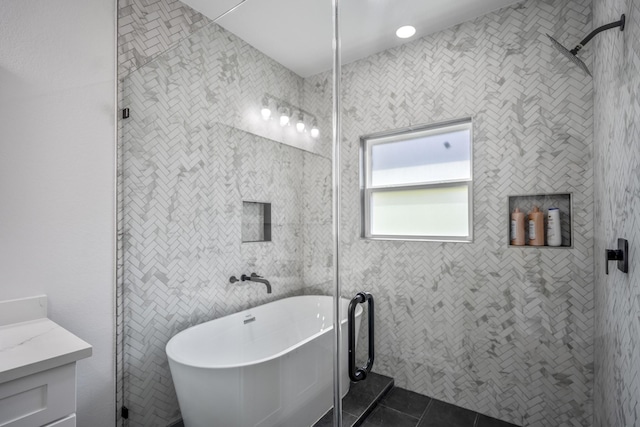 bathroom featuring tile patterned flooring, vanity, tile walls, and plus walk in shower