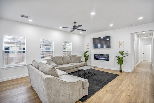 living room featuring ceiling fan and light hardwood / wood-style flooring