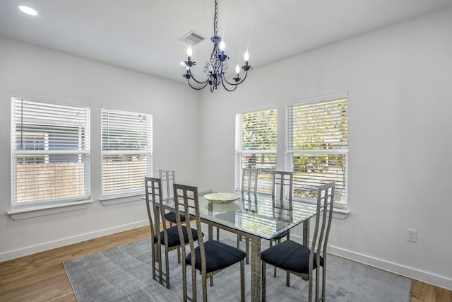 dining area featuring a notable chandelier, wood-type flooring, and a wealth of natural light