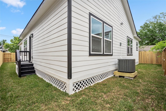 view of side of home with a lawn and central air condition unit