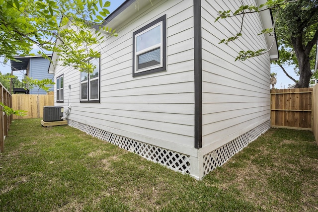 view of home's exterior featuring central air condition unit and a lawn