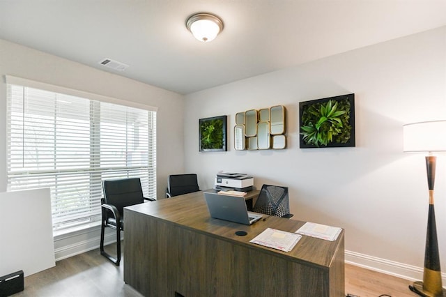 home office with wood-type flooring and a wealth of natural light