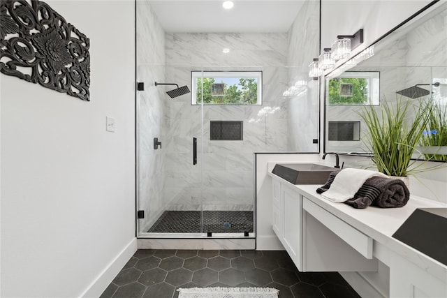 bathroom with a marble finish shower, recessed lighting, vanity, baseboards, and tile patterned floors