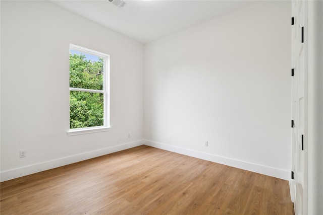 unfurnished room with baseboards, visible vents, and light wood finished floors