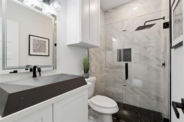 full bathroom with toilet, a shower stall, and vanity