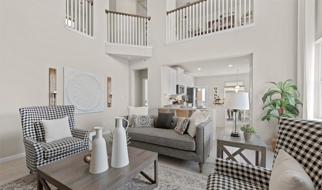 living room with a towering ceiling and light hardwood / wood-style floors