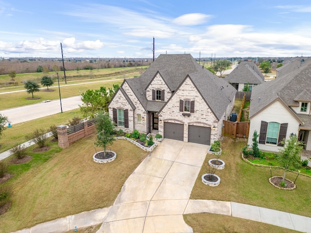 view of front of home with a garage, an outdoor fire pit, and a front lawn