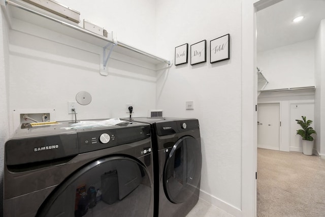 clothes washing area with washer and dryer and light colored carpet