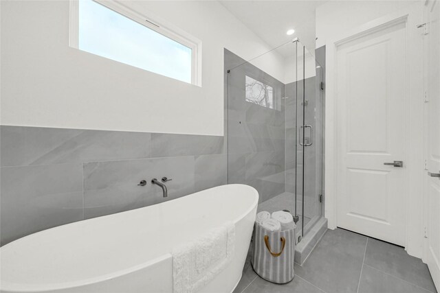 bathroom featuring tile patterned floors, independent shower and bath, and tile walls