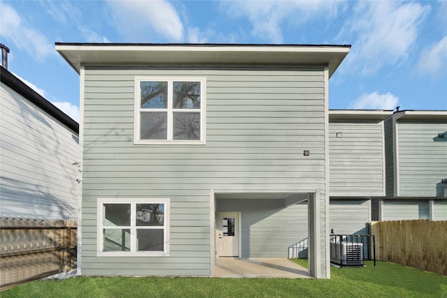 back of property with a patio area, a yard, and cooling unit