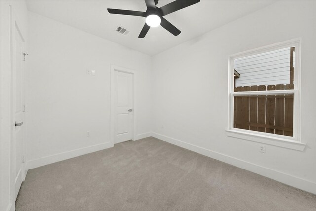 unfurnished room featuring light carpet and ceiling fan