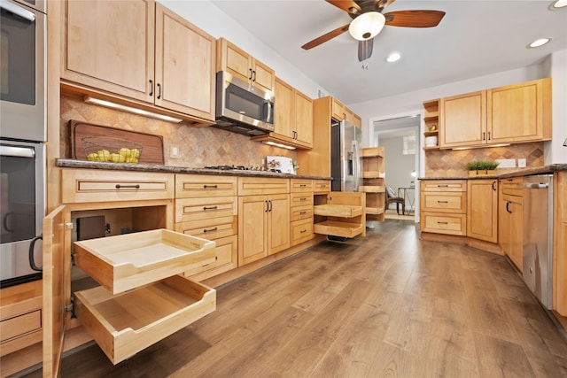 kitchen featuring tasteful backsplash, light brown cabinets, and stainless steel appliances