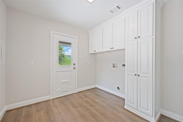 clothes washing area with cabinets, washer hookup, and light hardwood / wood-style floors