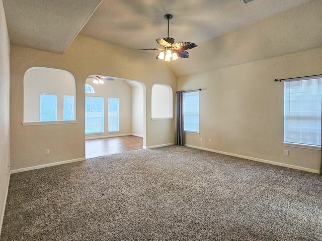 unfurnished room featuring carpet floors, vaulted ceiling, and ceiling fan