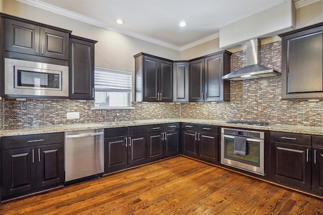 kitchen featuring light stone countertops, appliances with stainless steel finishes, dark hardwood / wood-style flooring, tasteful backsplash, and wall chimney exhaust hood