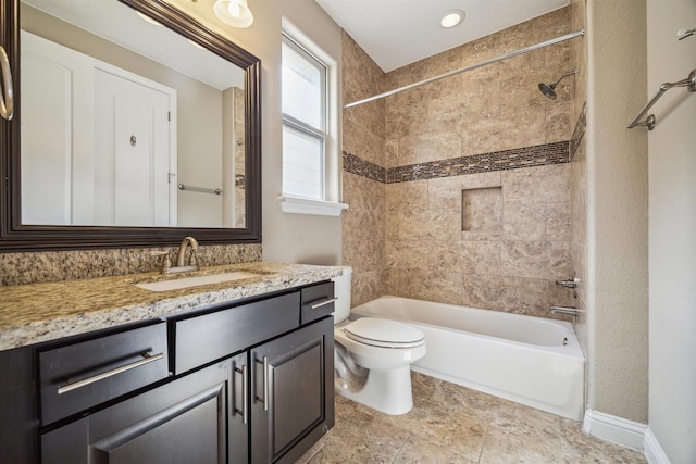 full bathroom with tiled shower / bath, vanity, and toilet