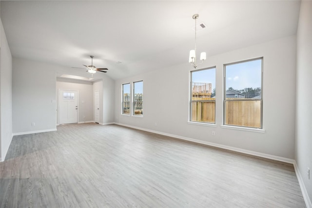 unfurnished living room with ceiling fan with notable chandelier and light hardwood / wood-style flooring