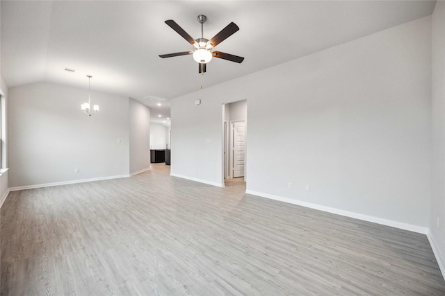 unfurnished living room with ceiling fan with notable chandelier, wood-type flooring, and vaulted ceiling