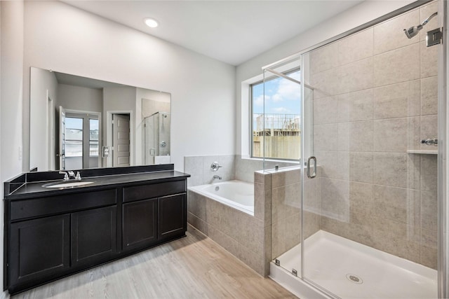 bathroom featuring vanity, independent shower and bath, and hardwood / wood-style flooring