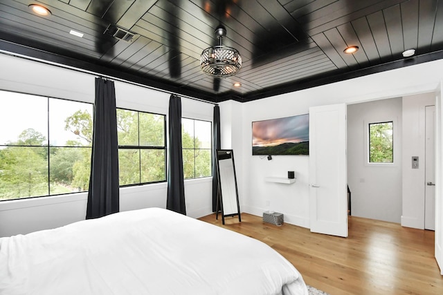 bedroom featuring light hardwood / wood-style flooring and wooden ceiling