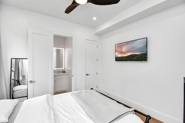 bedroom featuring connected bathroom, ceiling fan, sink, and wood-type flooring