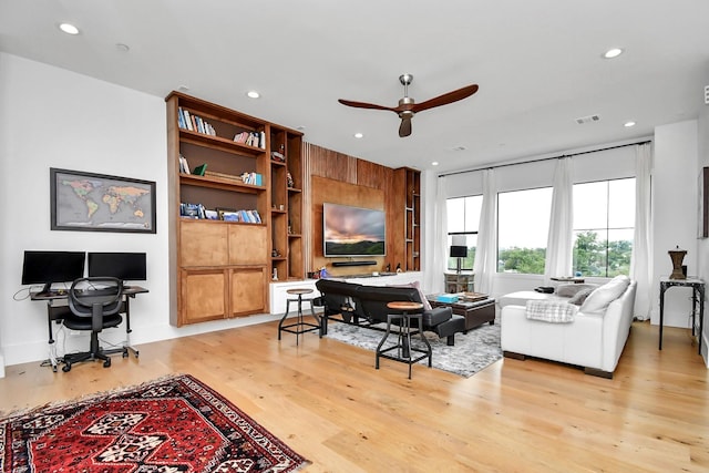 living room featuring ceiling fan and light hardwood / wood-style flooring