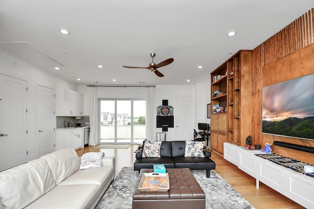 living room featuring light hardwood / wood-style floors, ceiling fan, and sink