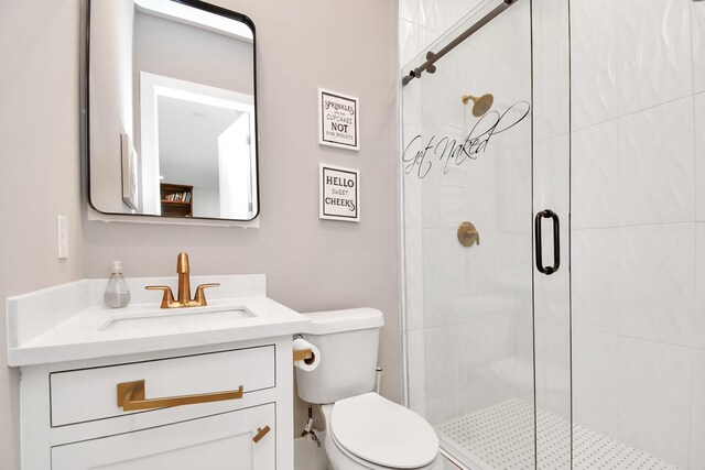 bathroom with an enclosed shower, vanity, and toilet