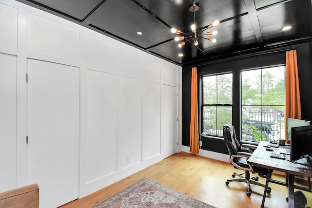 office space featuring a chandelier, light wood-type flooring, and coffered ceiling