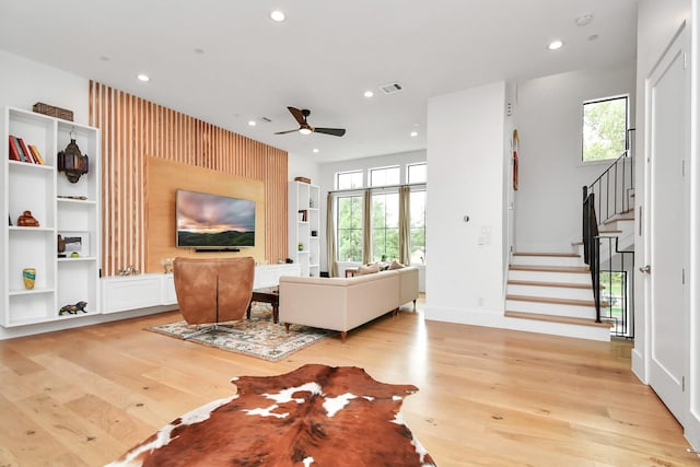 living room featuring ceiling fan and light hardwood / wood-style floors