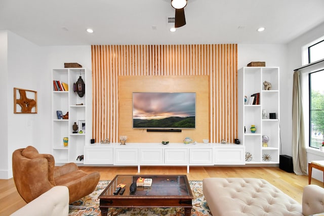 living room with ceiling fan and light wood-type flooring