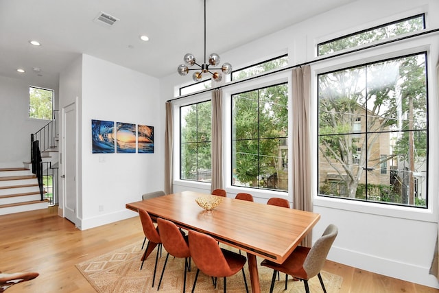 dining area featuring light hardwood / wood-style flooring and an inviting chandelier