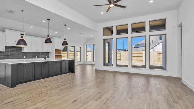 kitchen featuring light countertops, a large island, light wood-style floors, white cabinetry, and open floor plan