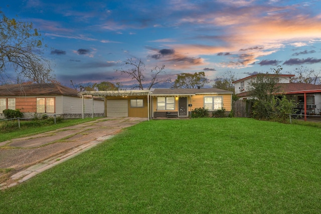 single story home featuring a lawn and a garage