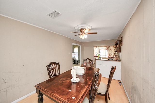 dining area with light hardwood / wood-style flooring and ceiling fan